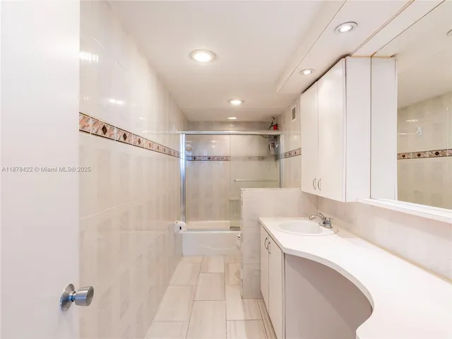 a bathroom with a sink mirror and a shower