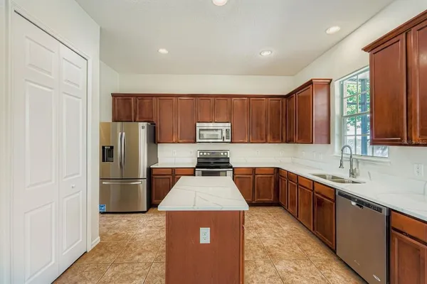 a kitchen with stainless steel appliances granite countertop a refrigerator stove and a sink