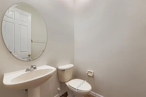 a bathroom with a sink a toilet and mirror