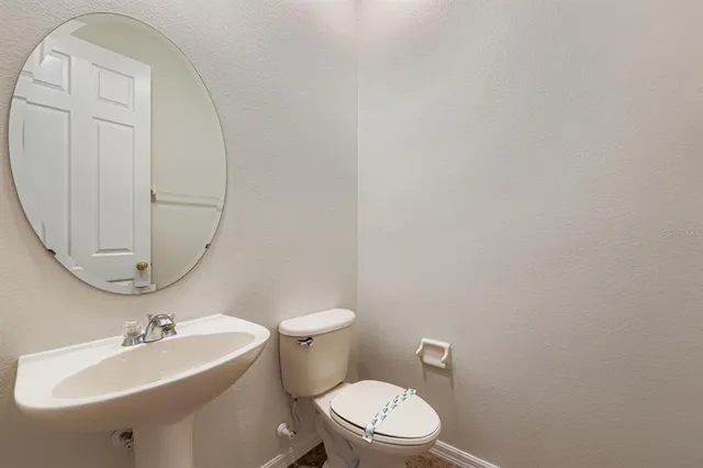 a bathroom with a sink a toilet and mirror