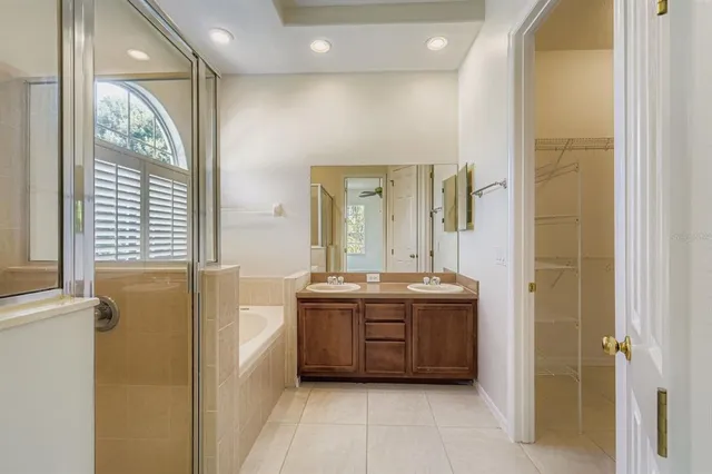 a spacious bathroom with a double vanity sink a mirror and a bathtub