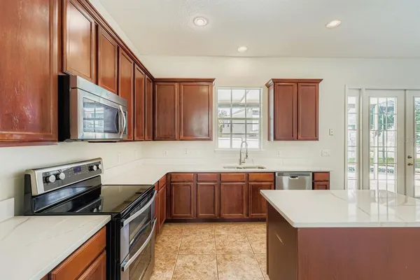 a kitchen with stainless steel appliances granite countertop a sink stove and cabinets