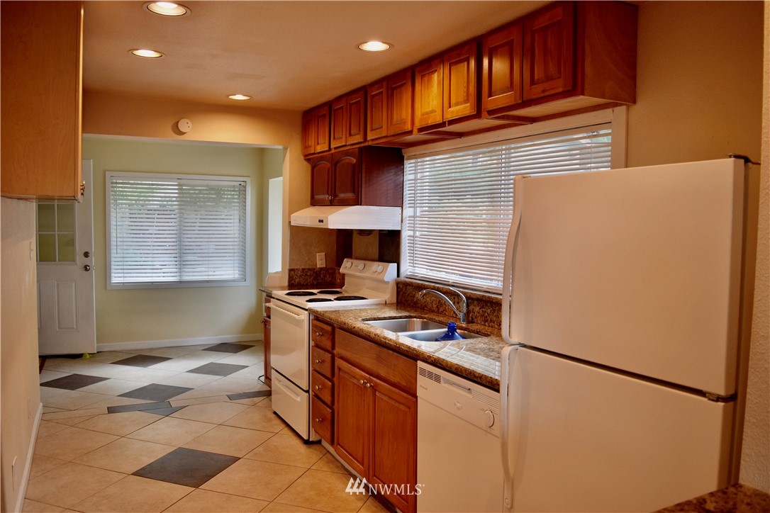 357 Lind Avenue Northwest Renton, WA 98057 - Photo 12 of 27 a kitchen with stainless steel appliances granite countertop a refrigerator stove top oven and sink