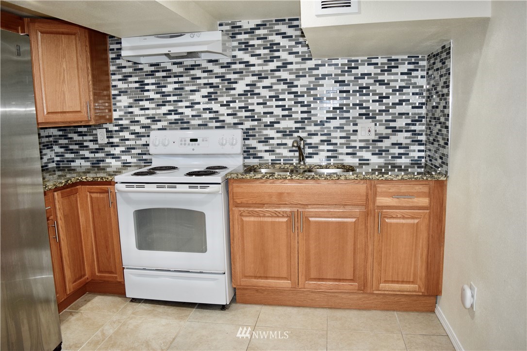 357 Lind Avenue Northwest Renton, WA 98057 - Photo 21 of 27 a kitchen with a stove and cabinets