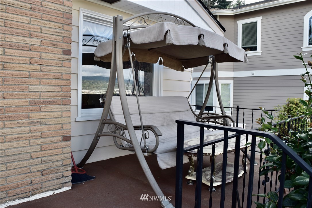 357 Lind Avenue Northwest Renton, WA 98057 - Photo 5 of 27 a view of a balcony with chairs and umbrella