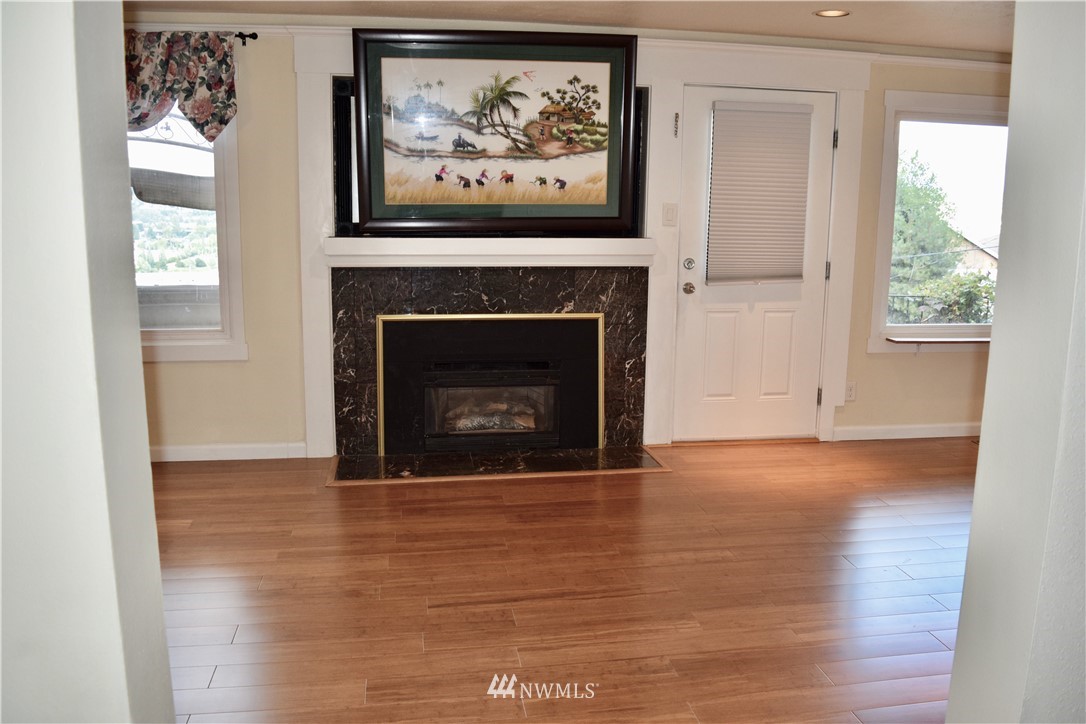 357 Lind Avenue Northwest Renton, WA 98057 - Photo 10 of 27 a view of a livingroom with a fireplace wooden floor and a window