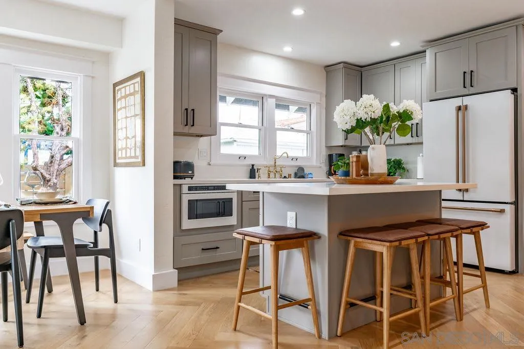 725 Pennsylvania Avenue San Diego, CA 92103 - Photo 27 of 64 a kitchen with stainless steel appliances kitchen island granite countertop a table chairs and a refrigerator