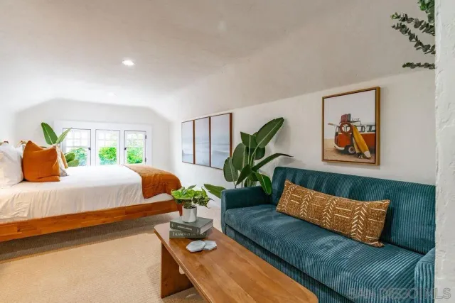 a bedroom with bed and a potted plant