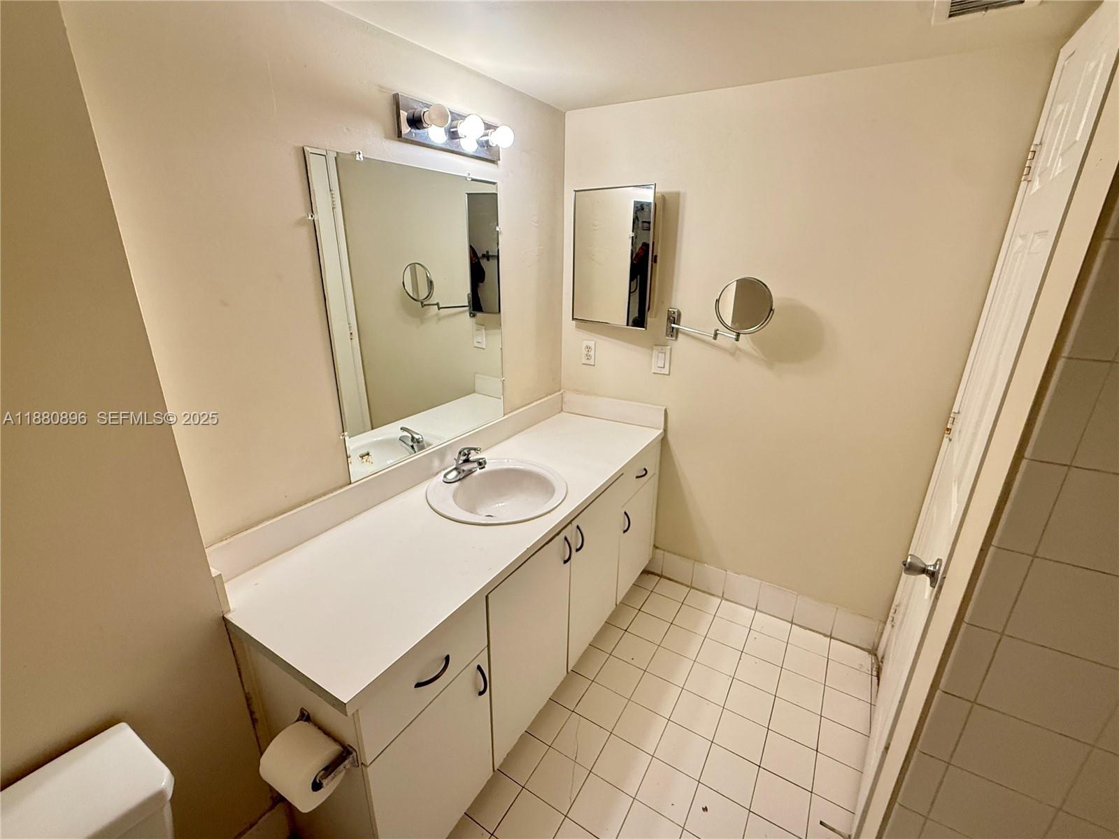 3870 Lyons Road, Unit 2108 Coconut Creek, FL 33073 - Photo 16 of 19 a bathroom with a sink a toilet and mirror