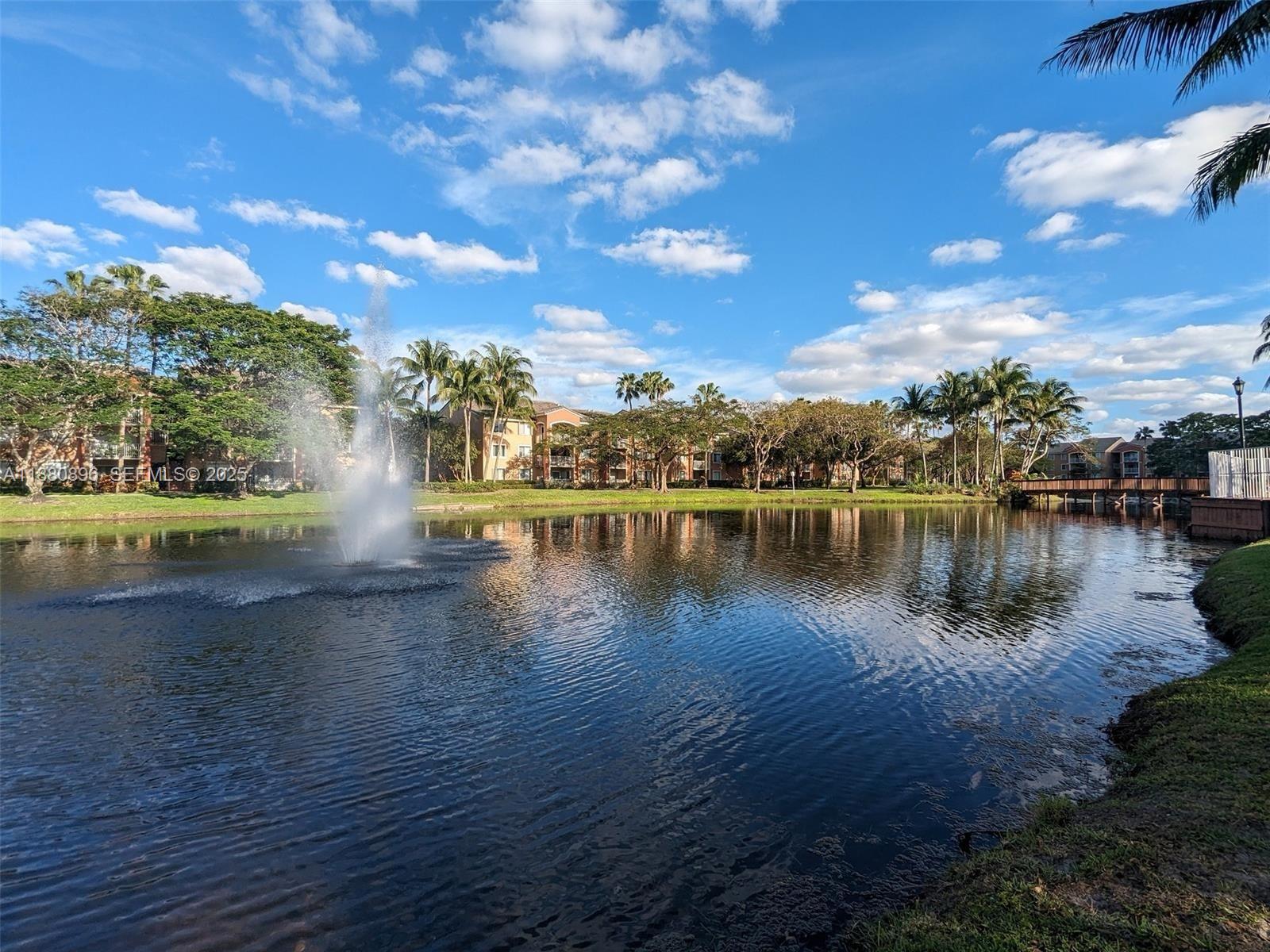 3870 Lyons Road, Unit 2108 Coconut Creek, FL 33073 - Photo 18 of 19 a view of a lake with houses in the back