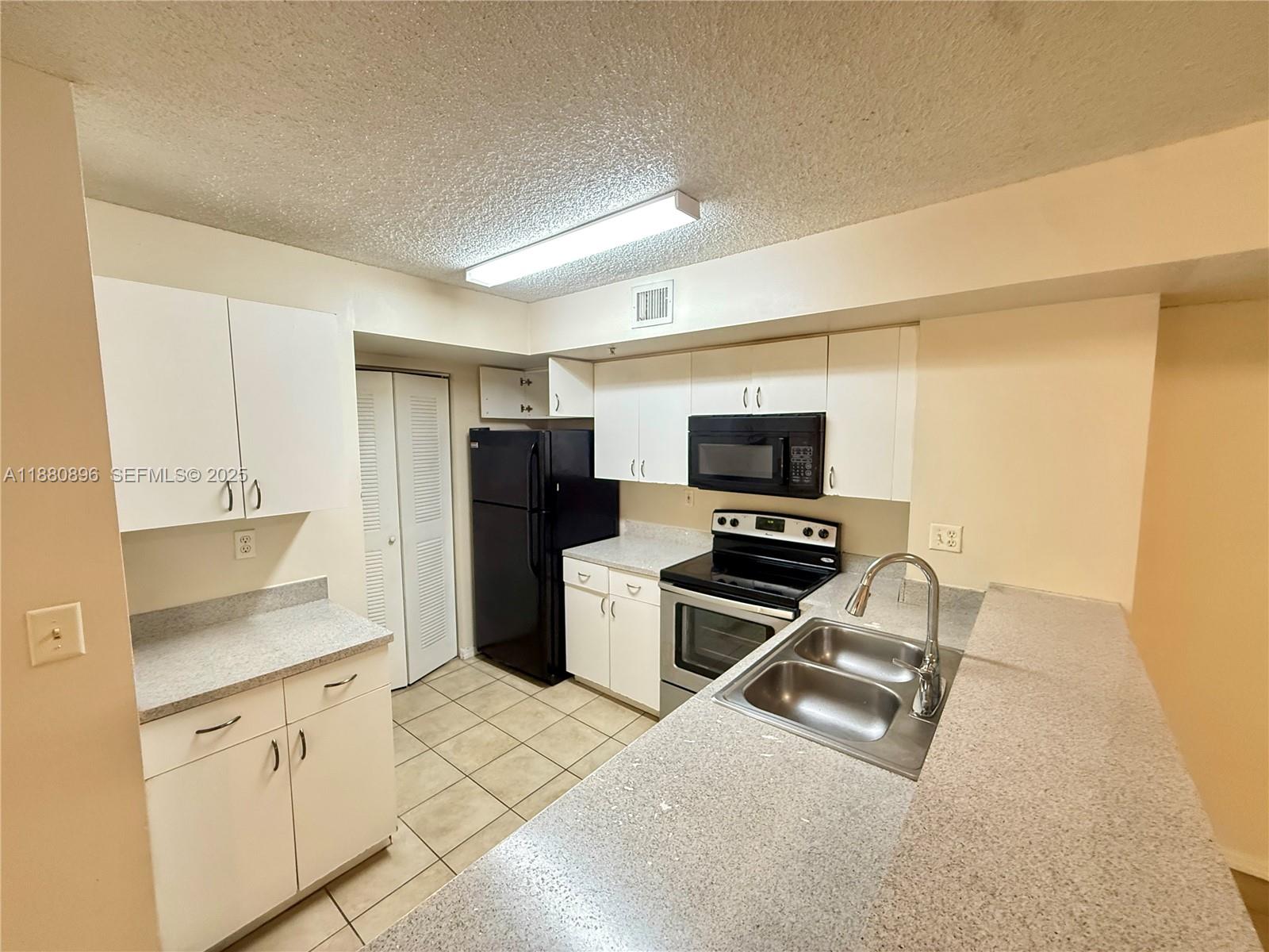 3870 Lyons Road, Unit 2108 Coconut Creek, FL 33073 - Photo 3 of 19 a kitchen with a stove a refrigerator and a sink