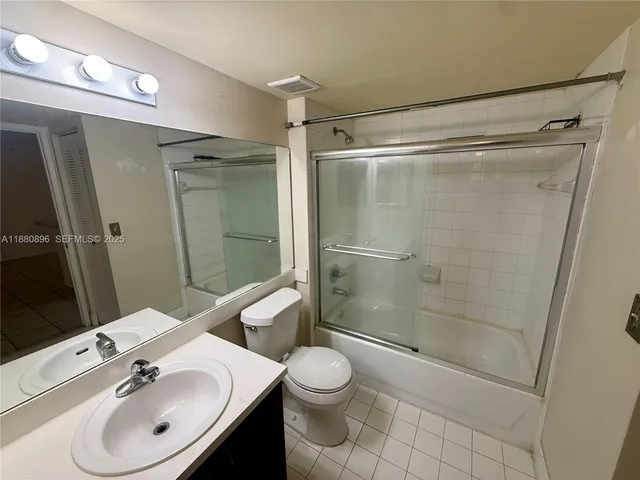 a bathroom with a shower sink vanity mirror and toilet