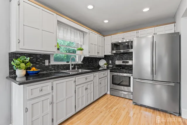 a kitchen with stainless steel appliances granite countertop a refrigerator sink and cabinets
