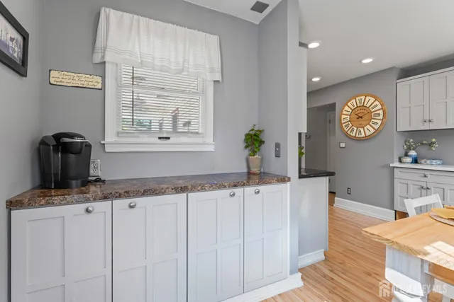 a kitchen with granite countertop a sink a stove a dining table and chairs