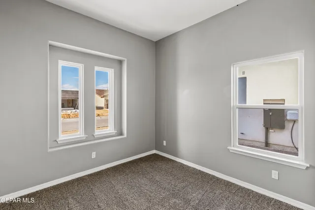 an empty room with windows and cabinet