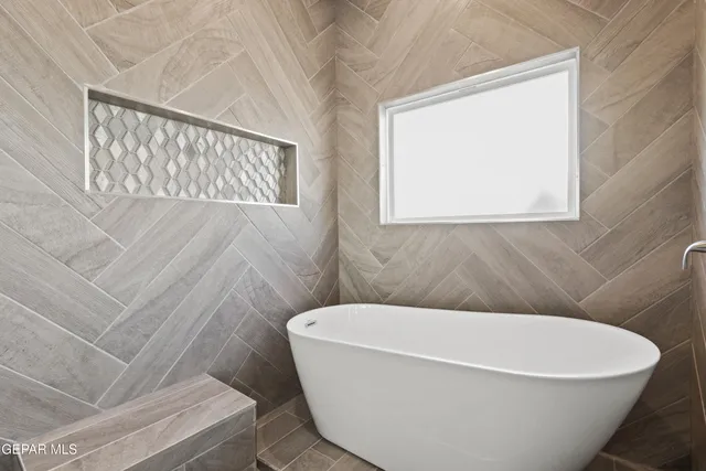 a white tub sitting next to a white window