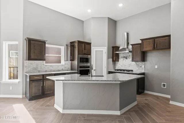 a kitchen with stainless steel appliances granite countertop a stove a sink and a refrigerator