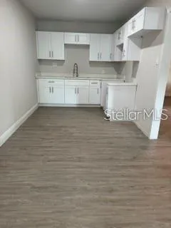 a view of kitchen with wooden floor and cabinets