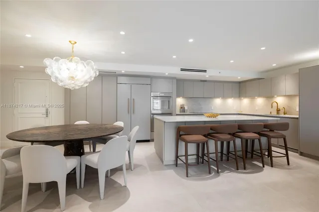 a kitchen with kitchen island a dining table and chairs
