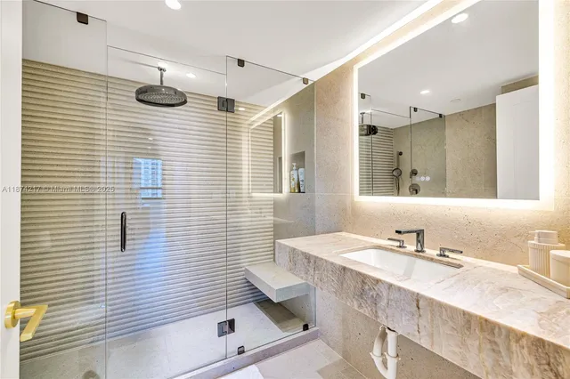 a bathroom with a granite countertop sink a toilet a mirror and shower