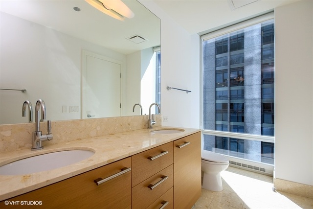 340 East Randolph Street, Unit 1606 Chicago, IL 60601 - Photo 14 of 29 a bathroom with a granite countertop sink and a mirror