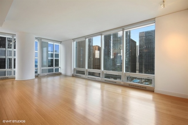 340 East Randolph Street, Unit 1606 Chicago, IL 60601 - Photo 3 of 29 a view of an empty room with wooden floor and a window