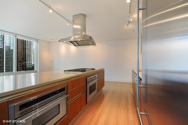 340 East Randolph Street, Unit 1606 Chicago, IL 60601 - Photo 5 of 29 a kitchen with wooden floor and stainless steel appliances
