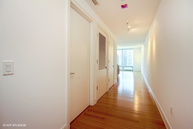 340 East Randolph Street, Unit 1606 Chicago, IL 60601 - Photo 9 of 29 a view of a hallway with wooden floor