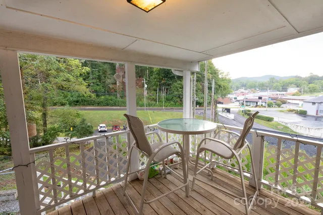 a view of a chairs and table in patio with wooden floor