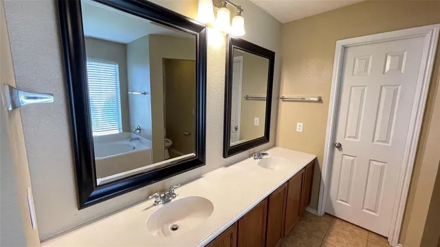 a bathroom with a tub sink and mirror