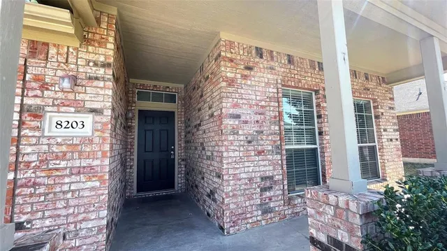 a view of front door of house with brick walls