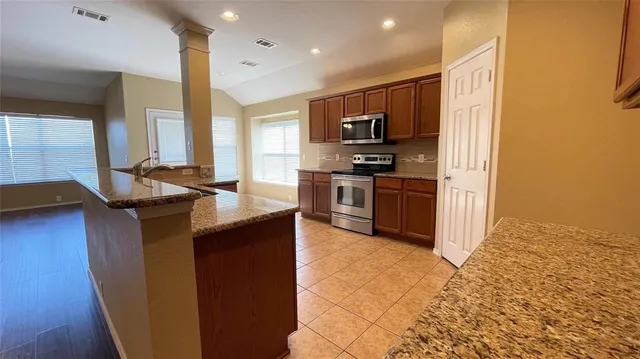 a kitchen with stainless steel appliances granite countertop a sink stove and refrigerator