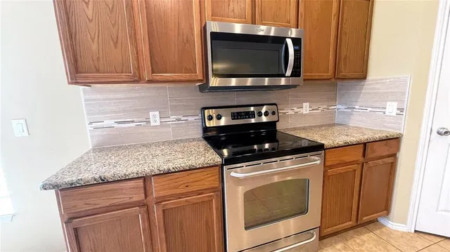 a kitchen with stainless steel appliances granite countertop a sink stove and microwave