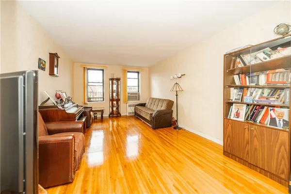 a spacious bedroom with a bed a dresser and a book shelf