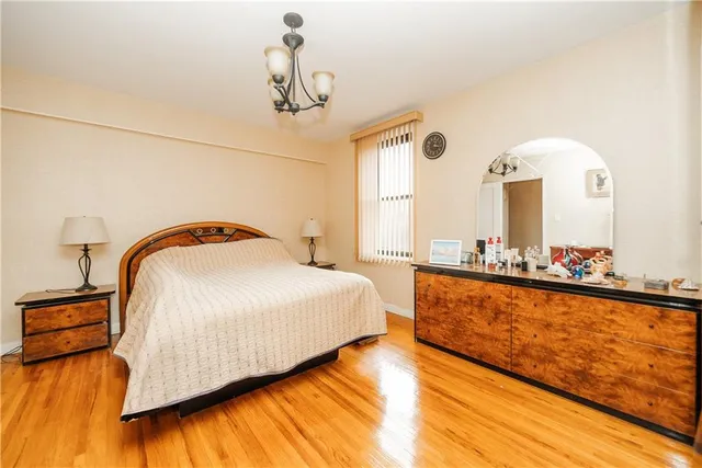 a bedroom with a bed and a night stand next to a window