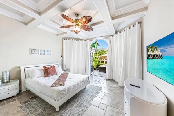 a spacious bedroom with a bed and a chandelier