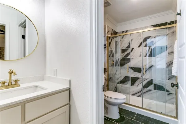 a bathroom with a granite countertop sink toilet and shower