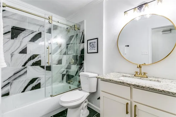 a bathroom with a granite countertop sink mirror vanity and toilet