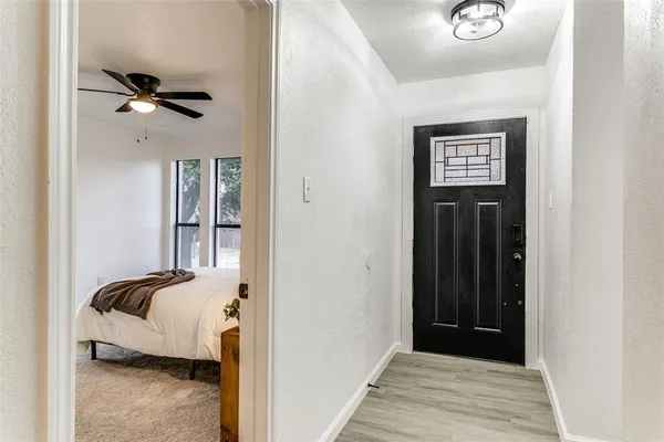 a view of a bedroom with a bed and wooden floor
