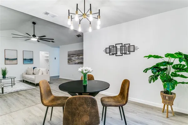 a dining room with furniture potted plants and wooden floor