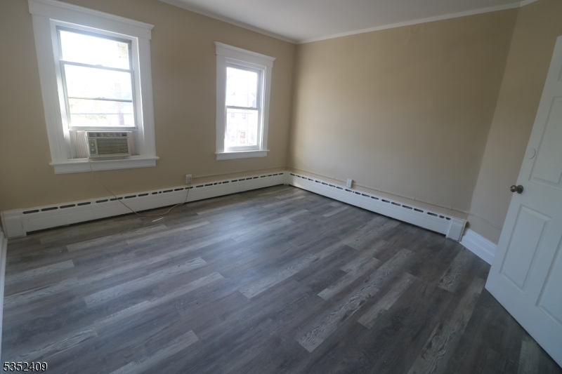 40 Mitchell Street West Orange, NJ 07052 - Photo 4 of 17 an empty room with wooden floor and windows