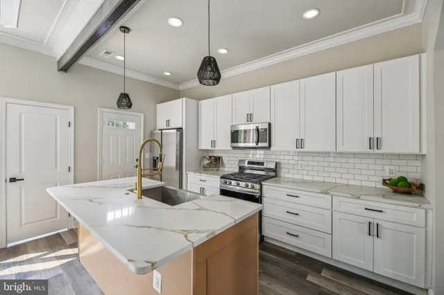 a kitchen with stainless steel appliances kitchen island granite countertop a sink a stove and cabinets