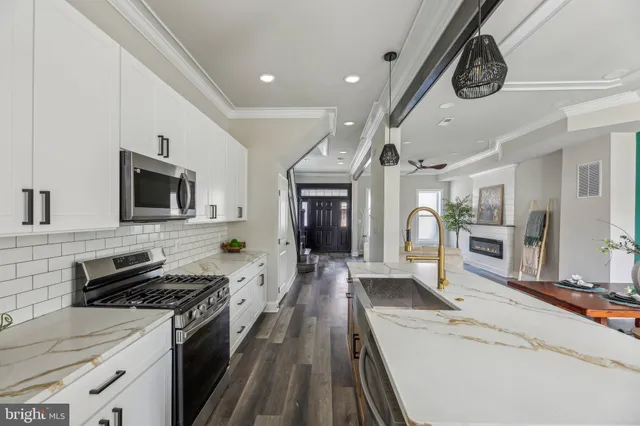 a large kitchen with stainless steel appliances granite countertop a lot of counter space and wooden floor