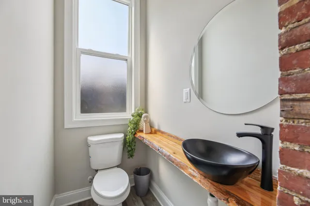 a bathroom with a toilet a sink and mirror