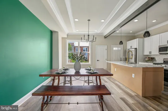a living room with furniture a rug kitchen view and a large window