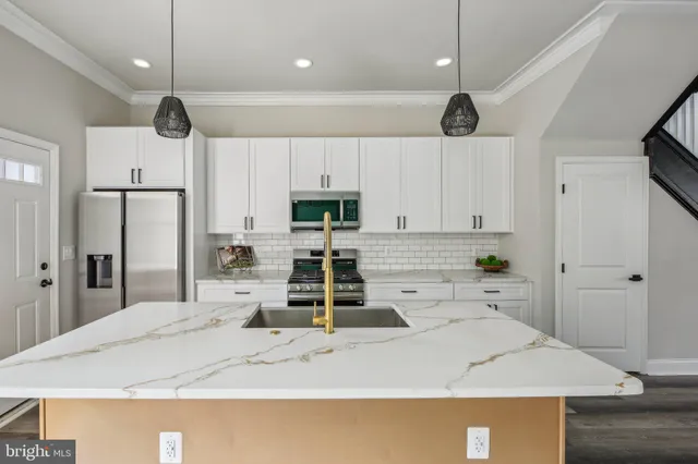 a kitchen with kitchen island a counter top space appliances and cabinets
