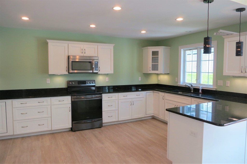 20 Bridge Road, Unit 35 Northampton, MA 01062 - Photo 8 of 25 a kitchen with stainless steel appliances granite countertop a stove a sink and a microwave