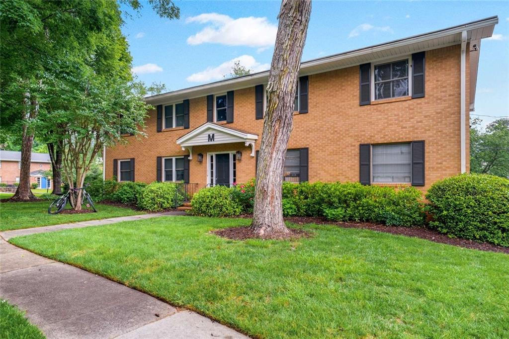 3510 Roswell Road Northwest, Unit M4 Atlanta, GA 30305 - Photo 2 of 23 a front view of a house with a yard and garage
