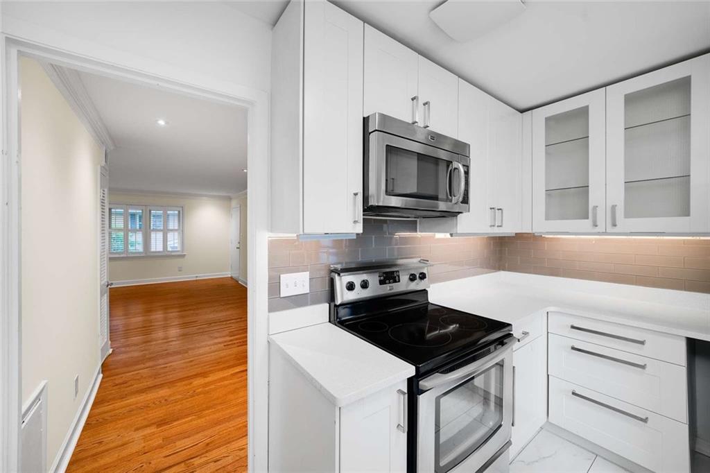 3510 Roswell Road Northwest, Unit M4 Atlanta, GA 30305 - Photo 10 of 23 a kitchen with stainless steel appliances white cabinets and stove top oven