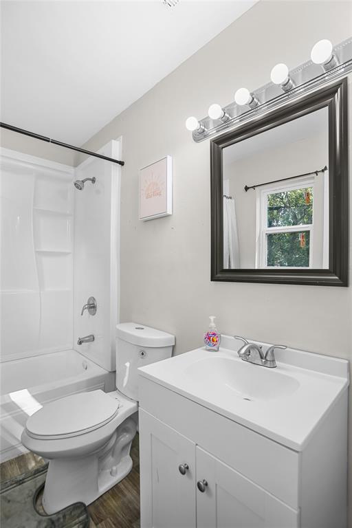 504 Preston Street Waco, TX 76704 - Photo 6 of 14 a bathroom with a toilet a sink a mirror and a shower